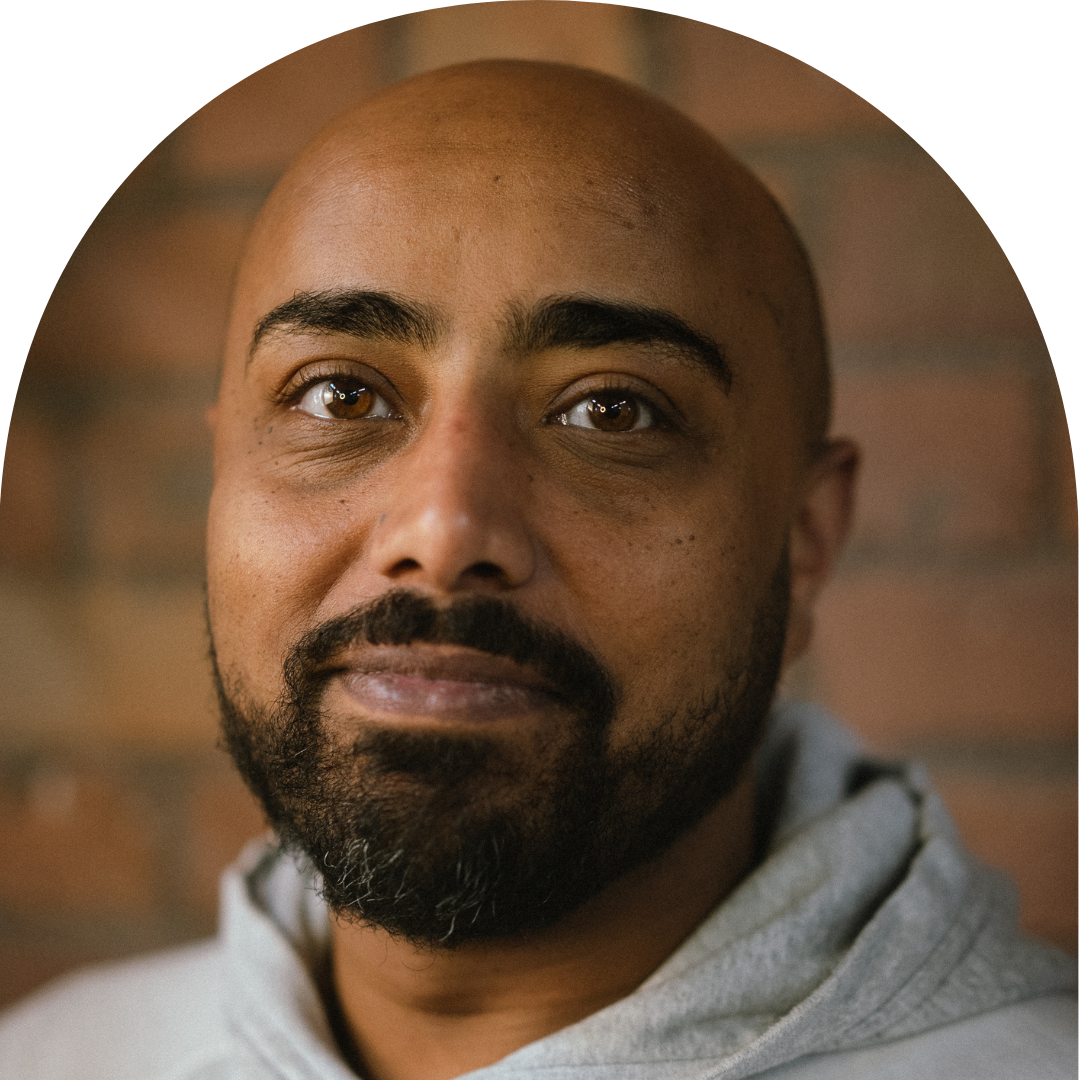 Man of colour with beard smiling at camera. Portrait.