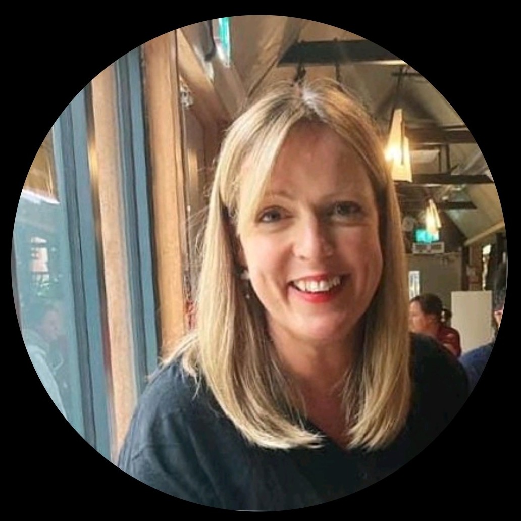 A smiling portrait of our trustee Claire inside a circular frame. Claire is Caucasian, with mid-length straight blonde hair. She is wearing red lipstick.