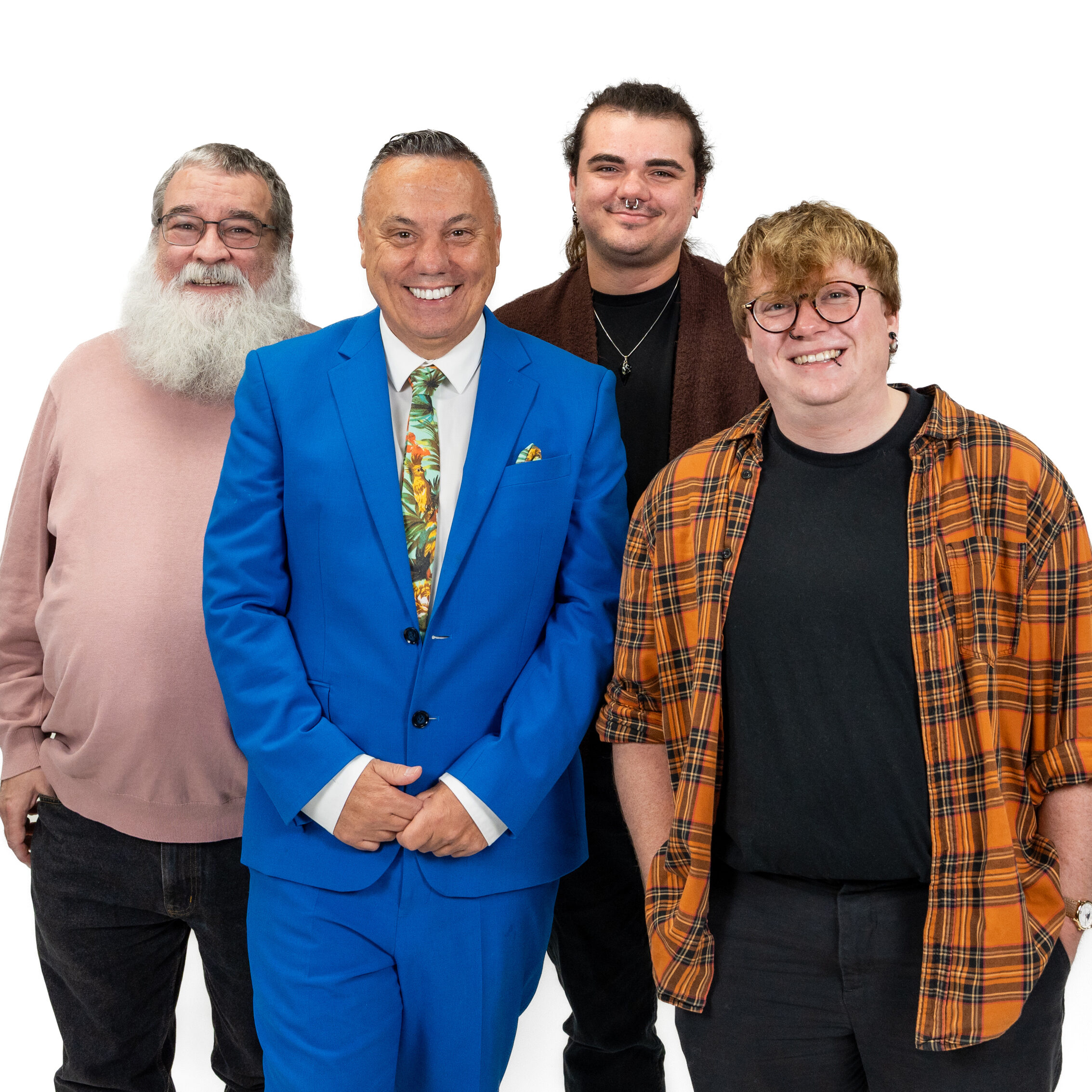 A group of LGBTQ+ men smiling and looking at the camera against a white backdrop for LGBT Foundation's Man Enough campaign