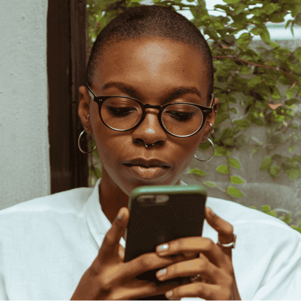 Black person with short hair using smartphone. Portrait.
