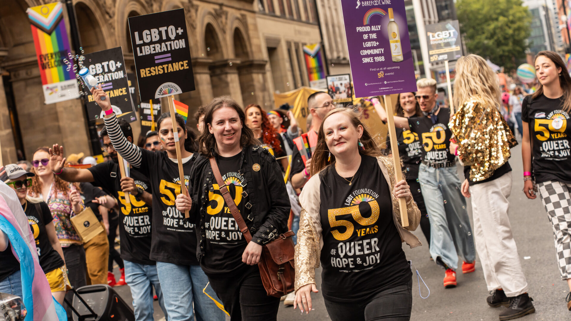 A group of LGBT Foundation staff holding placards in the Manchester Pride Parade 2025.